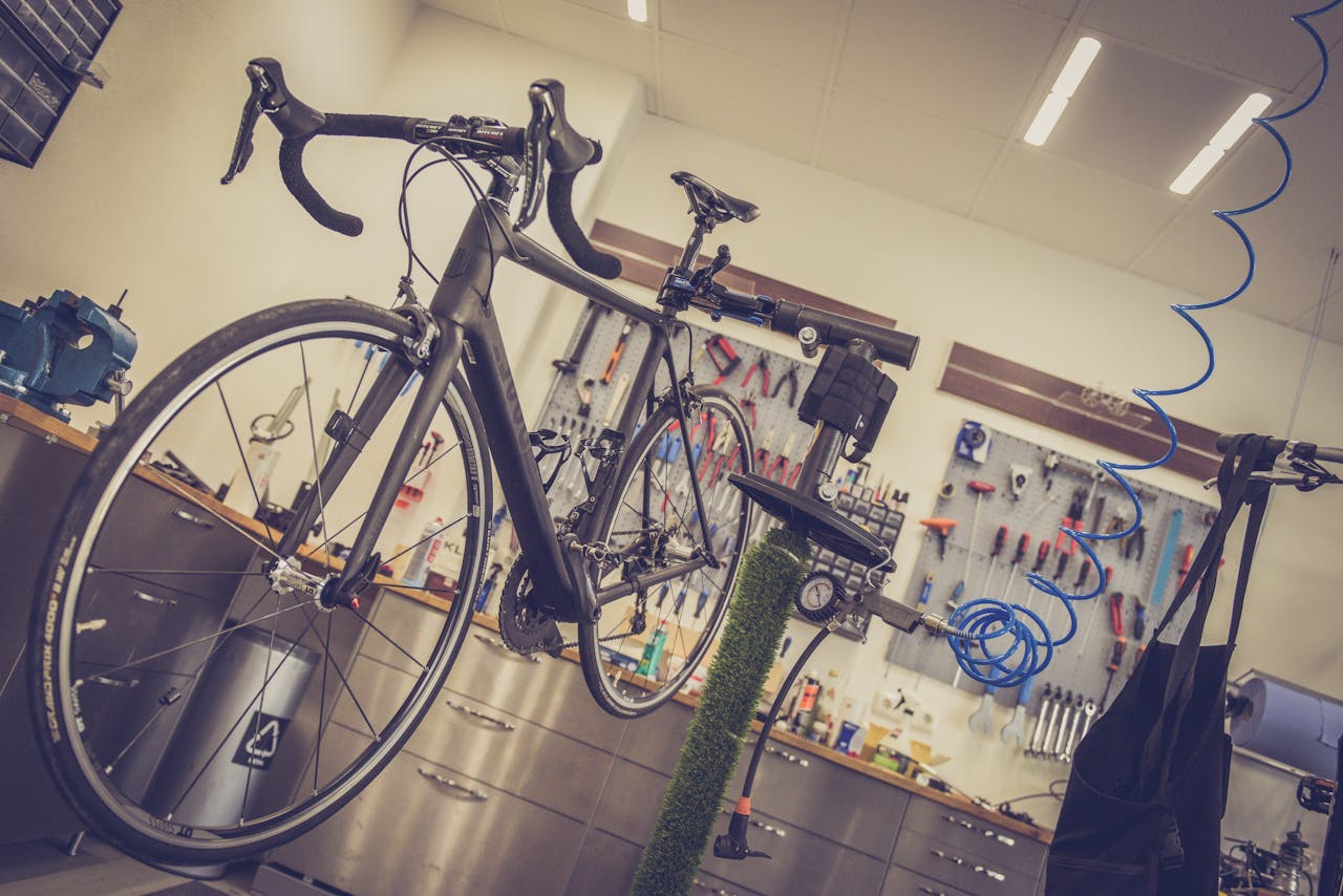 about-01 Detailed view of a bicycle being repaired in a modern workshop with tools and equipment.
